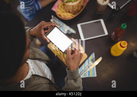 High angle view of man photographing fast-food fresh sur table à partir de téléphone mobile à cafe Banque D'Images