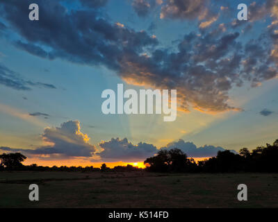 Magnifique coucher de soleil avec des rayons de lumière À TRAVERS LA COULÉE LE CIEL AU-DESSUS DE LA RIVIÈRE LUANGWA MFUWE, PRÈS DE BUSH CAMP, SOUTH LUANGWA NATIONAL PARK, Zambie Banque D'Images