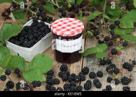 Rubus fruticosus. Confiture de Mûres faite maison avec une nourriture de Punnett et mûres bramble feuilles sur une table en bois dans le septembre. UK Banque D'Images