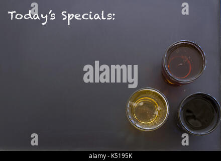 Un assortiment de verres de bière sur tableau noir avec Todays Specials et copiez l'espace. Banque D'Images