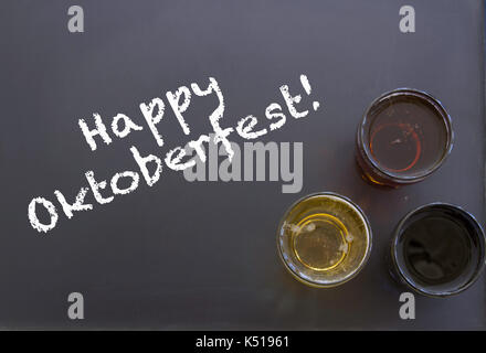 Un assortiment de verres de bière sur tableau noir avec craie blanche heureux dans l'Oktoberfest. Banque D'Images