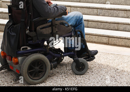 Utilisateur de fauteuil roulant en face de barrière d'escalier Banque D'Images