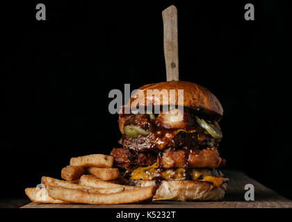 Burger de viande double avec oignon frit, fromage et piments jalapeños marinés Banque D'Images