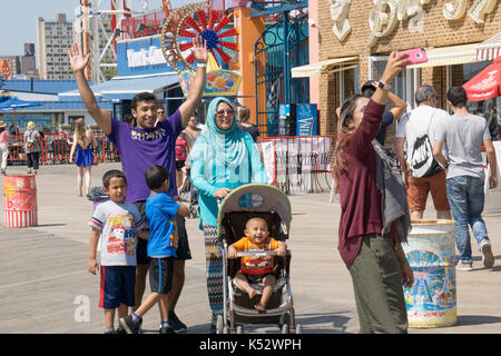 Une famille musulmane de prendre une promenade sur les selfies dans Consy Island, Brooklyn, New York. Banque D'Images