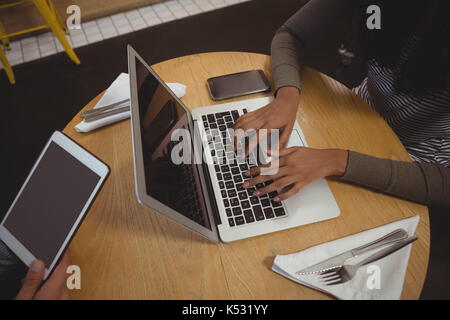 Portrait de femme à l'aide d'ordinateur portable à la table en bois dans la région de cafe Banque D'Images