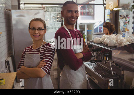 Portrait of smiling certain jeunes propriétaires standing in cafe Banque D'Images