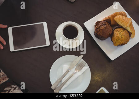 Portrait de café et muffins avec tablette numérique sur table in cafe Banque D'Images