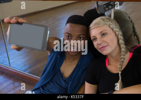 Jeune danseur avec amie prenant en selfies dance studio Banque D'Images
