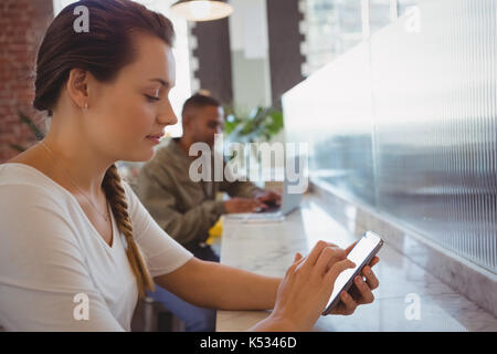 Young waitress using digital tablet in cafe Banque D'Images