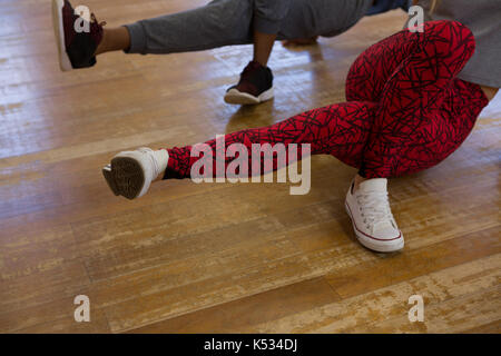 La section basse de danseurs en répétition sur plancher de bois franc en studio Banque D'Images