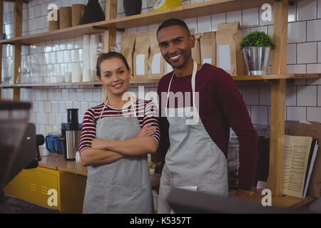 Portrait of smiling jeunes propriétaires standing in cafe Banque D'Images