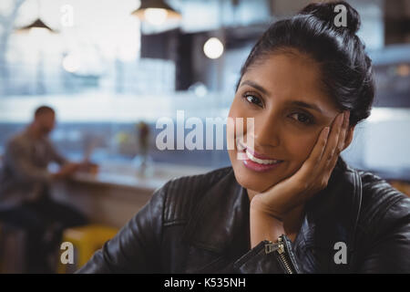 Close-up portrait of smiling woman with friend en arrière-plan au café Banque D'Images