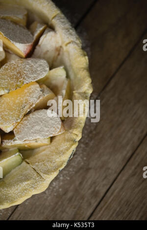 Close up de tranches de pomme sur la pâte feuilletée à plat sur une table en bois Banque D'Images