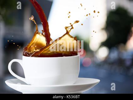 Digital composite de café est versé dans white cup contre rue floue Banque D'Images