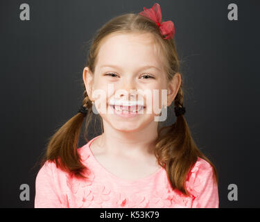 Jeune fille bénéficiant d''un verre de lait frais affichant une moustache blanche. Banque D'Images