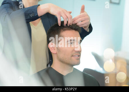 Coiffure masculine la coupe de cheveux de jeune homme dans un salon de coiffure Banque D'Images