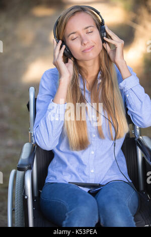 Les jeunes personnes handicapées woman relaxing with music dans la nature Banque D'Images