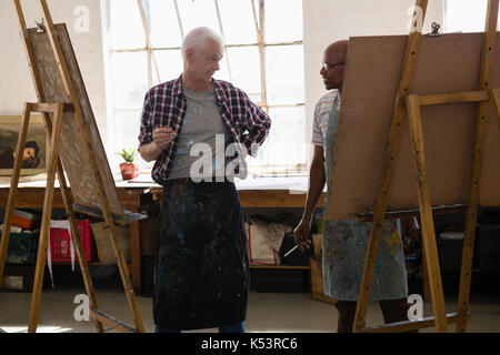 En parlant des hommes tandis que la peinture dans la classe d'art Banque D'Images
