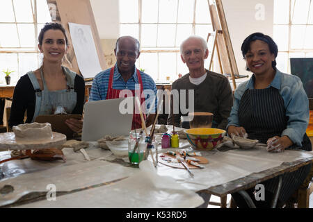 Portrait of senior amis assis à table avec l'enseignant dans la classe d'art Banque D'Images