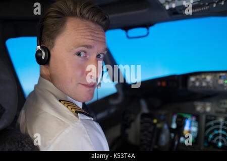 Close up portrait of handsome young male pilot in airplane cockpit Banque D'Images