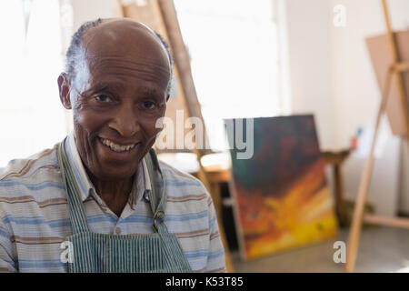 Close up portrait of smiling man sitting in art class Banque D'Images