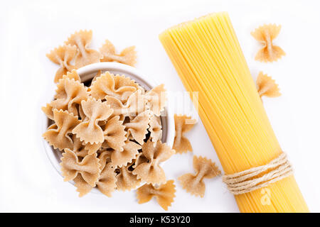 Pâtes farfalle organiques et des spaghettis isolated on white Banque D'Images