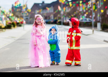 Les enfants à l'halloween trick ou traiter. les enfants en costume d'halloween avec des sacs de bonbons dans le quartier de la ville à pied décoré tour ou traitement. bébé et pr Banque D'Images