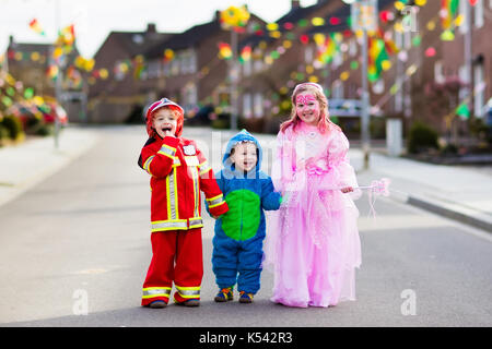 Les enfants à l'halloween trick ou traiter. les enfants en costume d'halloween avec des sacs de bonbons dans le quartier de la ville à pied décoré tour ou traitement. bébé et pr Banque D'Images