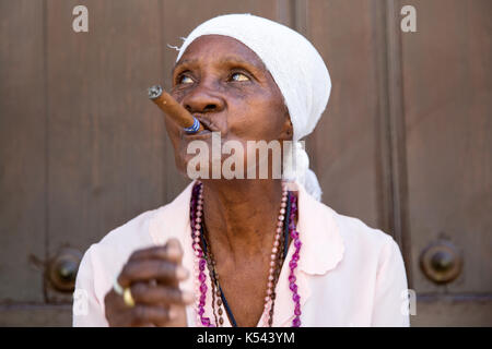 Vieille dame fume un cigare cubain sur les rues de La Havane, Cuba dans les Caraïbes Banque D'Images