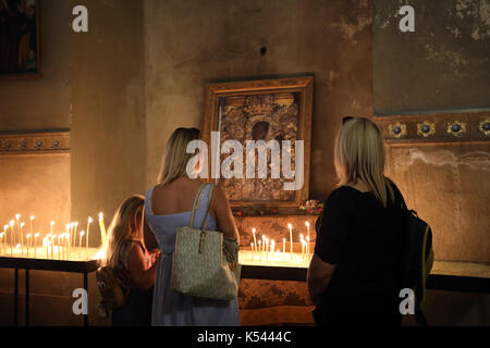 Pause pour les fidèles à la contemplation d'une icône de la Vierge à l'enfant, à l'intérieur de la cathédrale arménienne dans le centre de Lviv, Ukraine, le 27 août 2017. E Banque D'Images