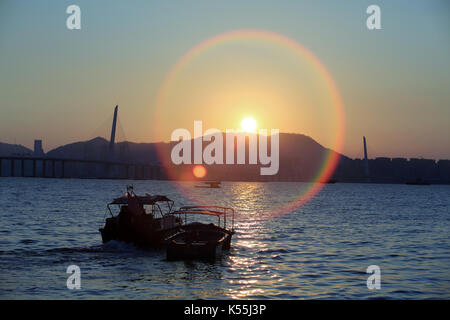 Scènes de hong kong,bateau de pêche passe par le soleil blast Deep Bay, la mer vue de Shenzhen à Hong Kong, pack ha nai ou lau fau shan village poisson Banque D'Images