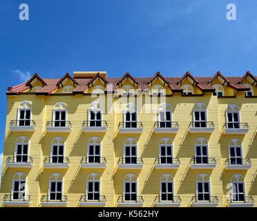 En copropriété avec des fenêtres blanches, d'un balcon, façade jaune et lucarnes dans Joo Chiat, Singapour. Banque D'Images