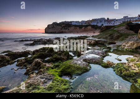 Coucher de soleil sur le village perché sur le promontoire dominant la plage de Carvoeiro Lagoa algarve Faro portugal Europe district Banque D'Images