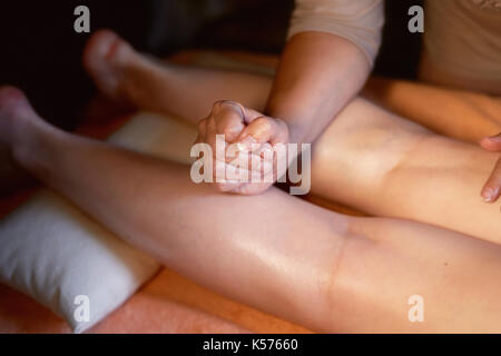 L'huile de sésame pour massage de relaxation des muscles du mollet. traitement pour jeunes femmes, Close up. massage sportif -jambe Massage - massage thérapeute physique faisant de veaux, appliquant une forte pression des doigts. tonique libre, selective focus. vue horizontale de veau femelle massage masseur Banque D'Images