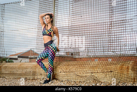 Couple après l'exercice appuyé contre une clôture Banque D'Images