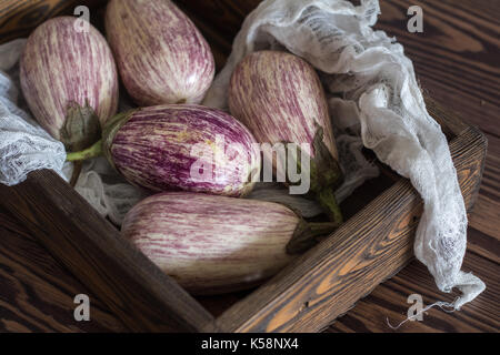 Aubergines graffiti violet dans une boîte en bois dans un fond de bois dans un style rustique, selective focus Banque D'Images