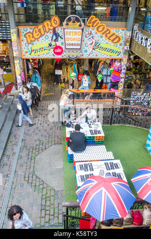 Les gens s'assoient à une table en face de retro monde fabriqué à partir de vieilles caisses appartenant à la céréale killer cafe à Camden market, Londres. Banque D'Images