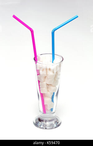 Grand verre plein de morceaux de sucre avec des pailles Banque D'Images