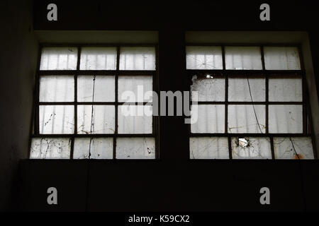 Broken windows industriel usine abandonnée à l'obscurité de l'intérieur. Banque D'Images