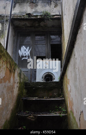 Maison abandonnée sous-sol escaliers et casse de machine à laver sur jour de pluie. Banque D'Images