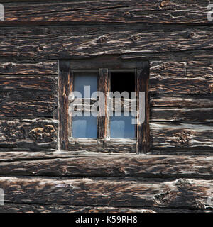 Ancienne petite fenêtre avec verre manquant dans cadre en bois, Livigno, italie Banque D'Images