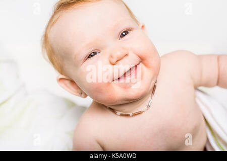 Portrait d'un bébé rampant sur le lit dans sa chambre Banque D'Images