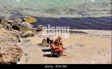 Couple bronzé à bronzer sur une plage Minorque Minorque espagne Banque D'Images