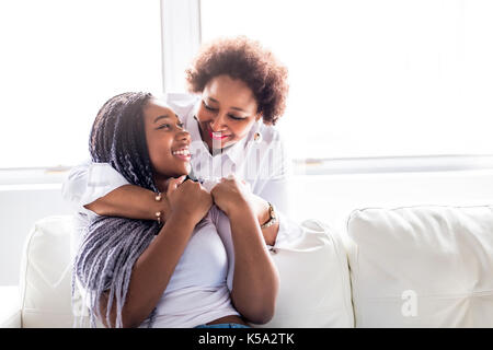 Une mère affectueuse et daughter sitting on sofa Banque D'Images