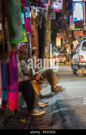 Katmandou, Népal - 23/9/2015 : Les vendeurs assis devant leurs boutiques dans le quartier de Thamel de Katmandou, Népal. Banque D'Images