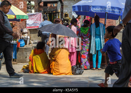 Katmandou, Népal - 9/26/2015 : un sadhu utilise un parapluie pour bloquer la chaleur au cours de l'Indra Jatra festival à durbar square de Katmandou, Népal. Banque D'Images