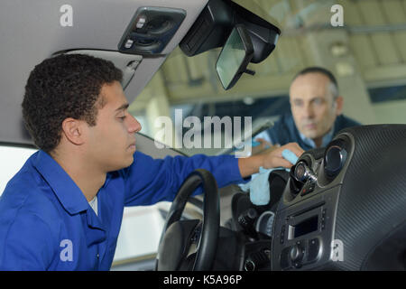 Le personnel de service auto nettoyage de l'intérieur d'une voiture Banque D'Images