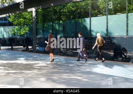 Les voyageurs passant par immeuble à Londres dans la matinée avec des sacs Banque D'Images