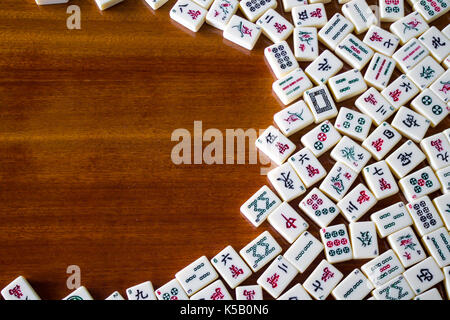 Tuiles de mahjong slide sur le côté droit de la table en bois Banque D'Images