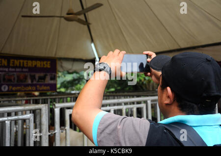 SEREMBAN, MALAISIE - août 31, 2016 : un homme en utilisant son téléphone portable pour prendre une photo en public. Banque D'Images